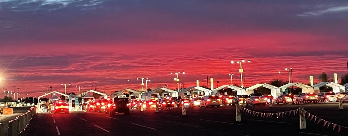 Photo of the PODs at the State Farm  Stadium parking lot at sundown. Cars lined up on each lanes to get vaccinated. This was taken during the COVID-19 outburst in 2020-2021.